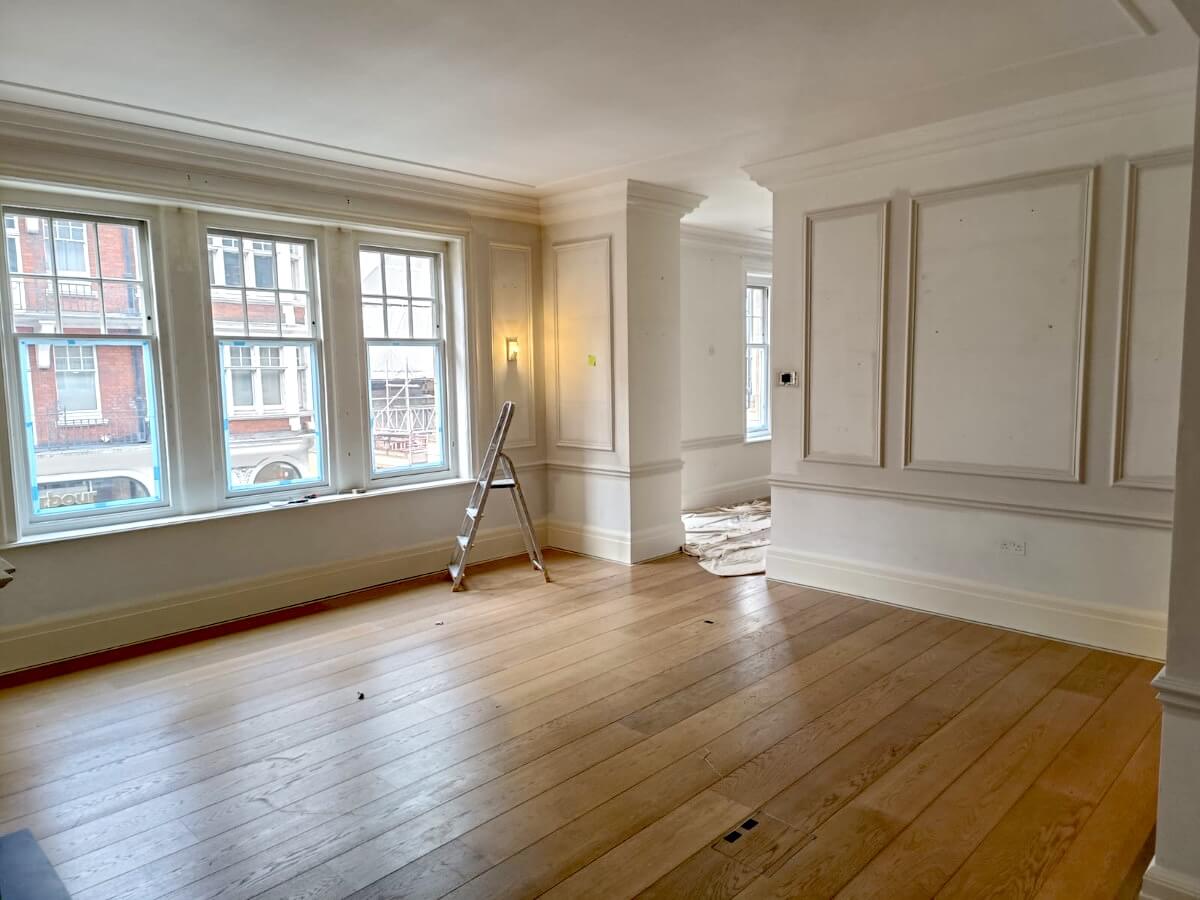 house-interior-painted-white-sunderland-foxglove-decor Empty living room with pale panelled walls, large windows and a wooden floor