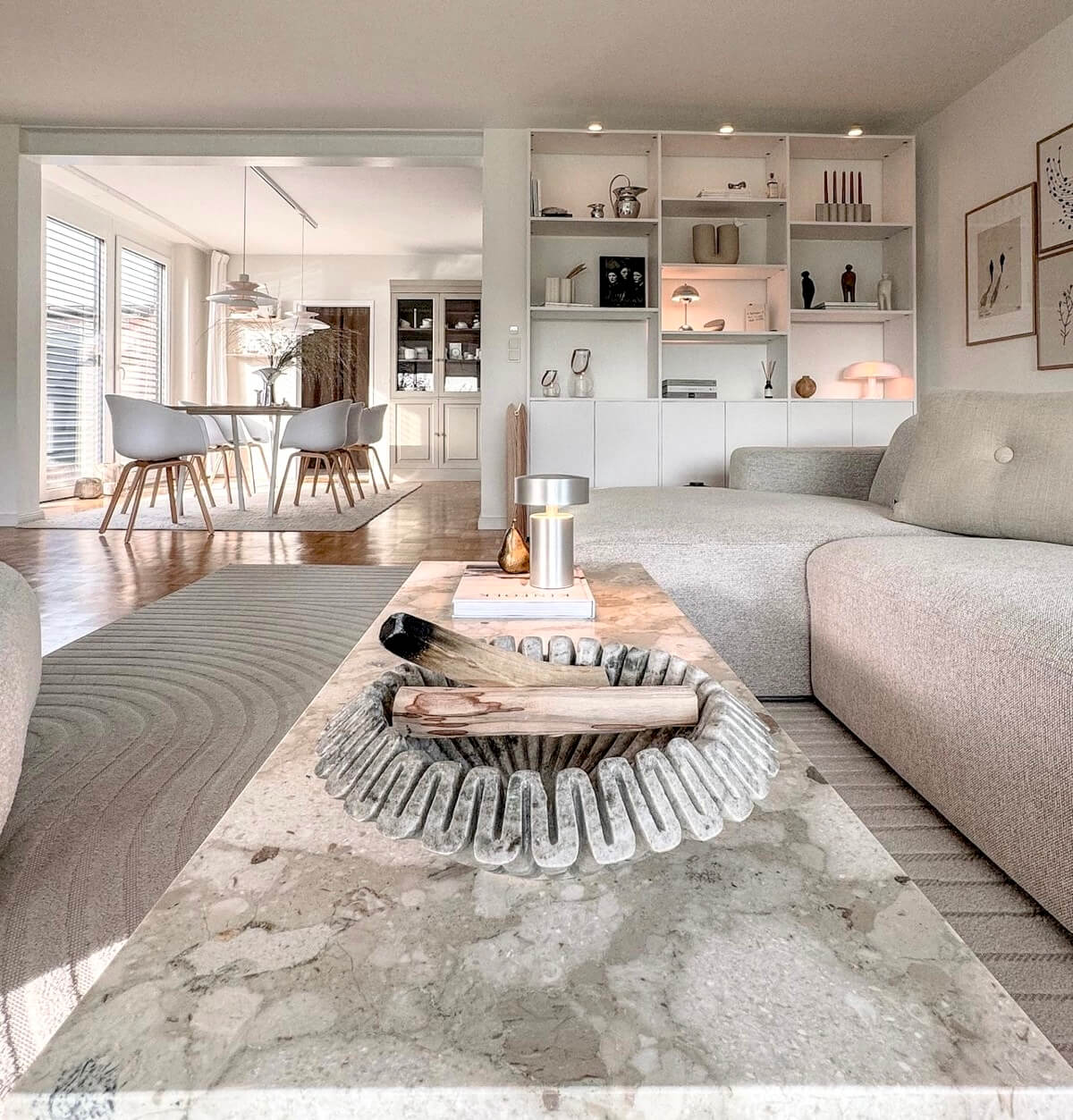 open-plan-living-room-walls-painted-sunderland-foxglove-decor Open-plan living room with a light sofa, a marble coffee table and white shelving beside a dining area