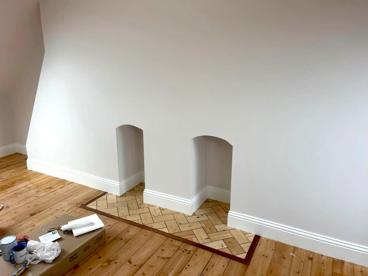 walls-wooden-trim-skirting-board-painted-sunderland-foxglove-decor Freshly painted white room with two alcoves, a parquet hearth and paint and tools on the floor